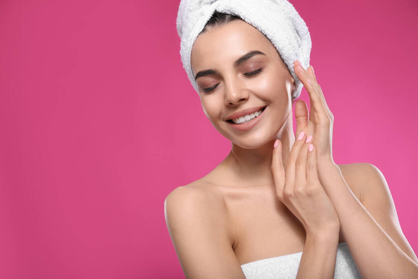 Happy young woman with towel on head against pink background, space for text. Washing hair - Foto, afbeelding