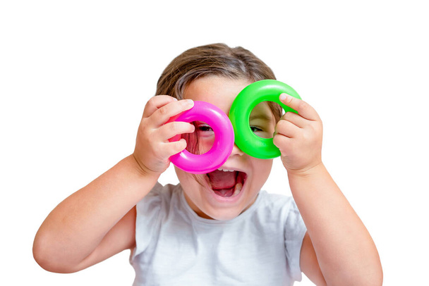 Child holds rings from toy pyramid as glasses isolated on white background - Fotó, kép