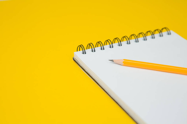 Enfoque selectivo del cuaderno, lápiz sobre un fondo amarillo y espacio de copia - Foto, Imagen