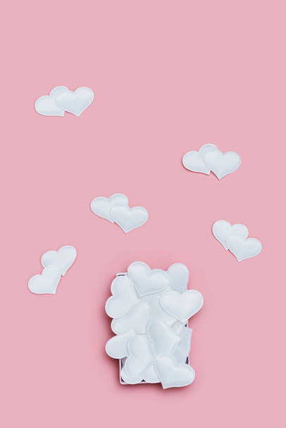 Creative Flat lay with White hearts on pink color. Love greeting card. Valentines day cards. Trendy fashion style pattern. Top view. - 写真・画像