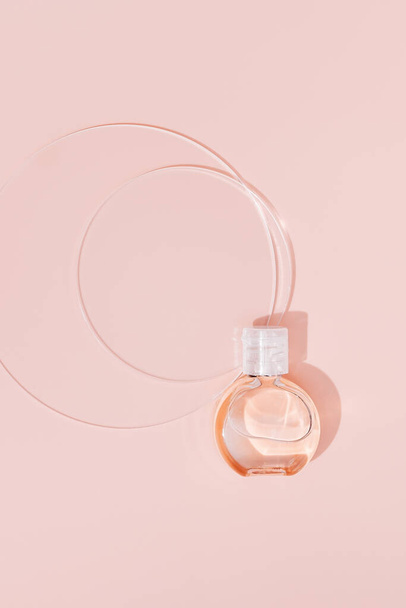 Beauty products mockups with glass circular disks. Small bottle with transparent gel on pale pink background. Skincare, body treatment concept. Top view. - Foto, afbeelding