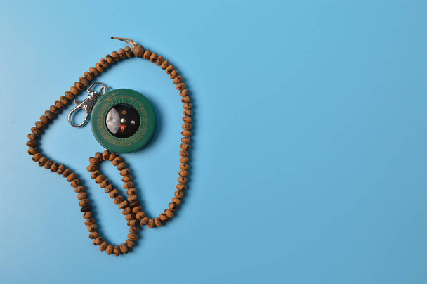 Muzułmański kompas qibla i paciorki modlitewne odizolowane na niebieskim tle - Zdjęcie, obraz