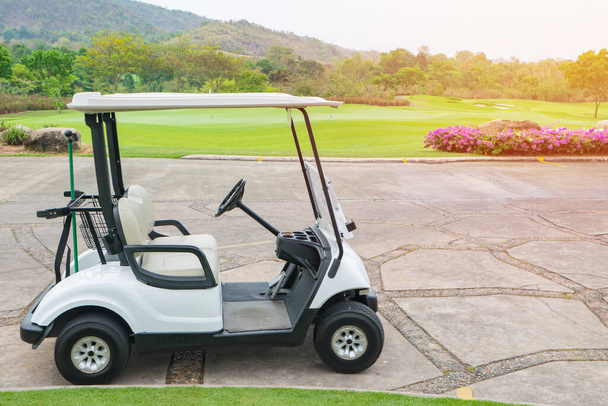 Клубний автомобіль або кошик для гольфу в полі для гольфу з зеленими газонами в сонячний день
. - Фото, зображення
