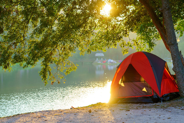 Toeristische tent in Camping tussen weide in de bergen in de buurt van meer op nationaal park. - Foto, afbeelding