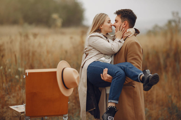 Beautiful couple spend time in a autumn field - Фото, изображение