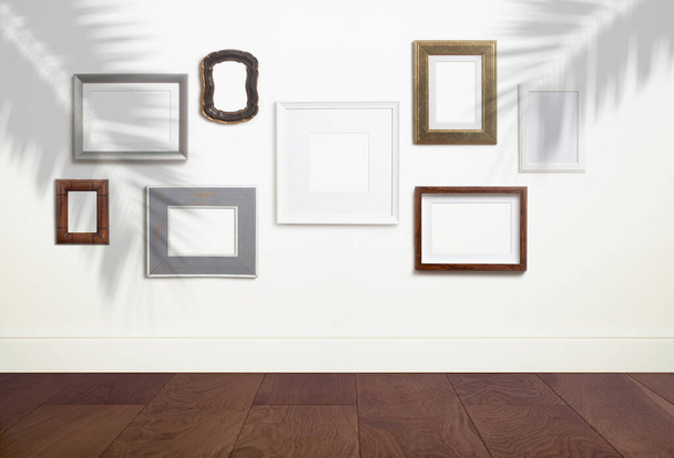 Vyhonit prázdné pozadí bílého rámce. Různé dekorativní prázdné rámy pro fotografii nebo malbu v lehkém skandinávském minimalistickém interiéru na bílé čisté zdi. - Fotografie, Obrázek