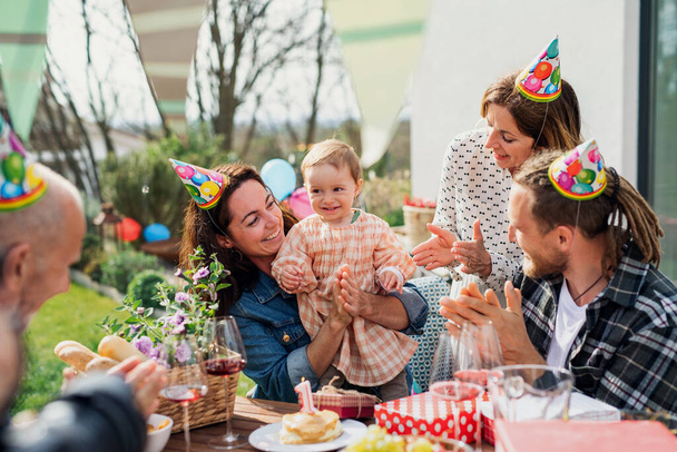 Happy multigeneration family outdoors in garden at home, birthday celebration party. - Photo, image