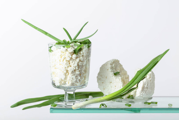Cottage sajt zöld hagymával üvegtálban, fehér alapon. Fénymásolási hely. - Fotó, kép