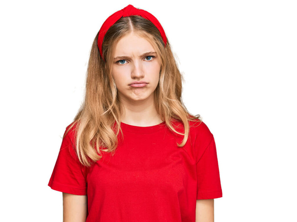 美しい若い白人の女の子が落ち込んでカジュアルな赤いTシャツを着て、苦痛を心配し、怒って恐れて泣いています。悲しい表情.  - 写真・画像