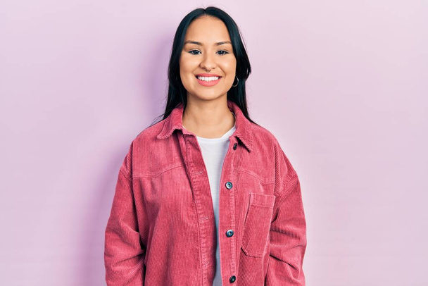 Beautiful hispanic woman with nose piercing wearing casual pink jacket with a happy and cool smile on face. lucky person.  - 写真・画像