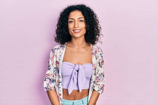 Menina latina jovem vestindo roupas casuais olhando positivo e feliz de pé e sorrindo com um sorriso confiante mostrando dentes  - Foto, Imagem