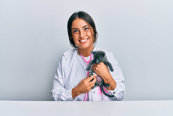 Молода іспано-ветеринарна дівчина вивчає кота за допомогою стетоскопа в клініці
. - Фото, зображення