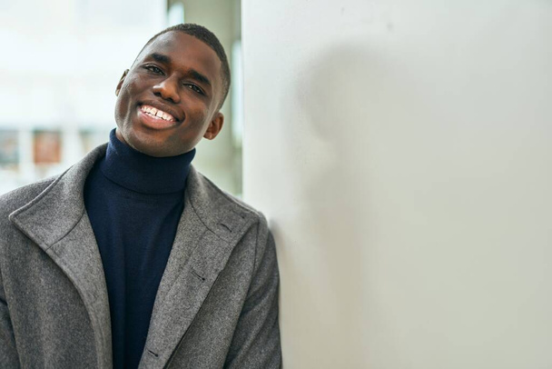 Nuori afrikkalainen amerikkalainen mies hymyilee onnellinen seisoo kaupungin - Valokuva, kuva