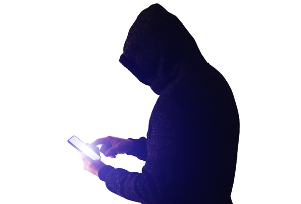 Mann in Kapuzenpulli mit einem Handy auf weißem Hintergrund. Süchtig nach Internet und sozialen Netzwerken. Guy hackt persönliche Daten. - Foto, Bild