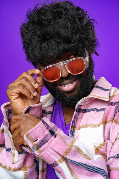 Fashion portrait of african american man in glasses against purple background - Foto, Bild