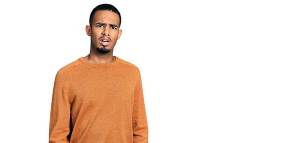 Young african american man wearing casual clothes in shock face, looking skeptical and sarcastic, surprised with open mouth  - Photo, Image