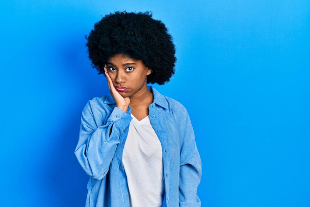 若いアフリカ系アメリカ人女性を身に着けているカジュアル服を考え疲れていると退屈でうつ病の問題で交差腕.  - 写真・画像