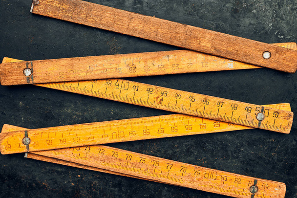 Wooden measure. Old ruler on metal surface. Measuring tool. Technical background with copy space - Fotografie, Obrázek