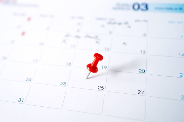 Selektiver Fokus. Das Foto eines Kalenders mit roter Nadel am 26. März. Konzept der Planung. - Foto, Bild