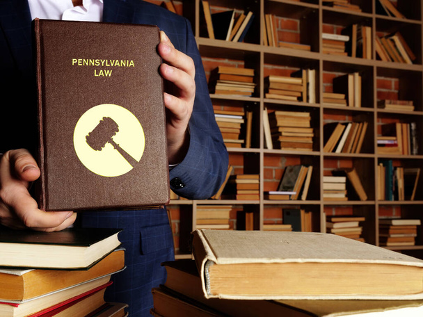  PENNSYLVANIA LAW livre entre les mains d'un juriste. Les résidents de Pennsylvanie sont soumis à la loi fédérale de l'État de Pennsylvanie et des États-Unis - Photo, image