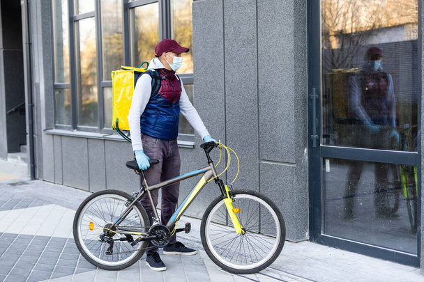 Junger Zusteller mit gelbem Rucksack-Imbiss-Konzept - Foto, Bild