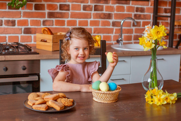 mała słodka dziewczyna z koszem pisanek w kuchni w domu - Zdjęcie, obraz