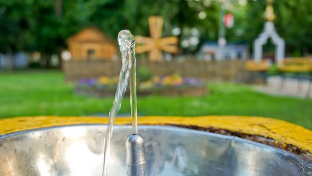 La fuente de agua potable en el parque de la ciudad no solo sacia la sed, sino que también sirve como decoración.  - Foto, Imagen