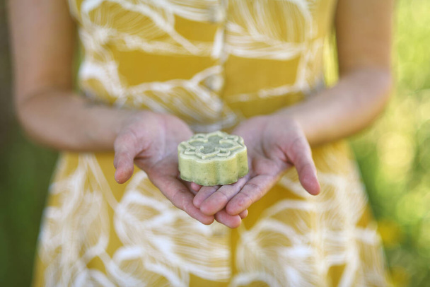 Mujer muestra jabón hecho a mano y orgánico en el bosque  - Foto, imagen