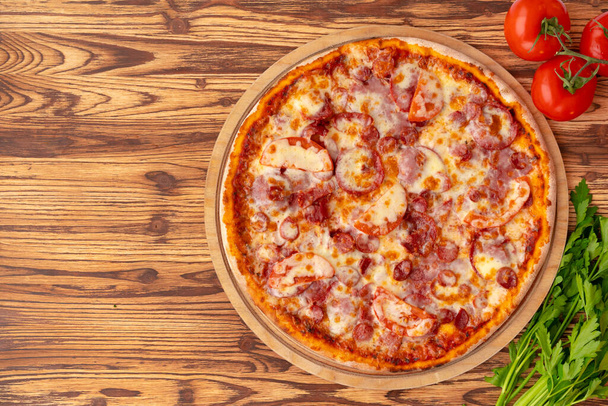 Top view of freshly baked pizza on wooden background - Photo, Image