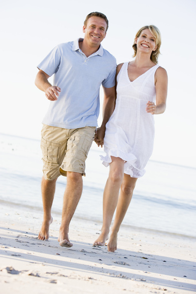 Couple at the beach holding hands and smiling - Foto, immagini