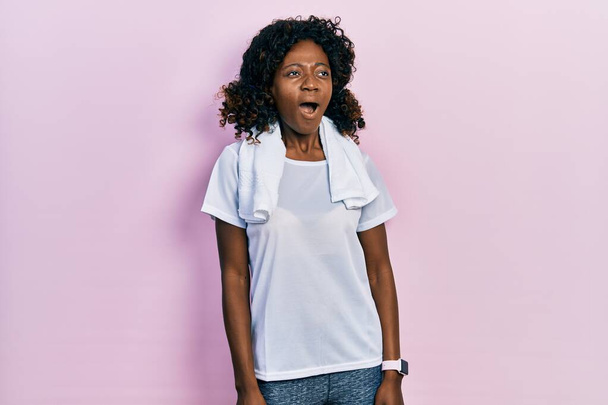 Mladá Afroameričanka ve sportovním oblečení a ručníku rozzlobená a šíleně ječela, frustrovaná a rozzuřená, křičela vzteky. vztek a agresivní koncept.  - Fotografie, Obrázek