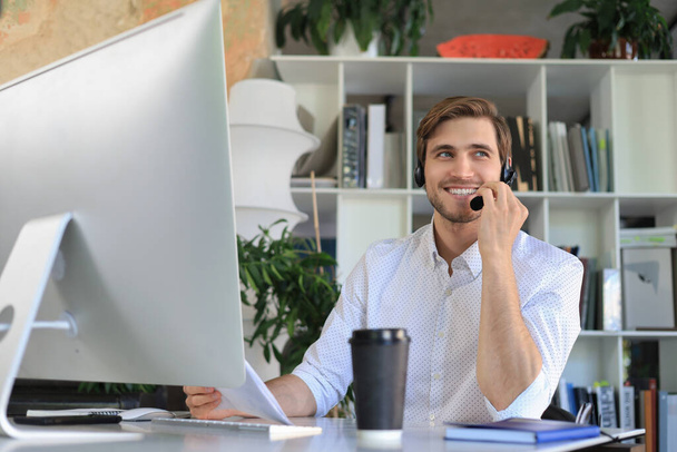 Smiling young business man having video call in office - Photo, Image