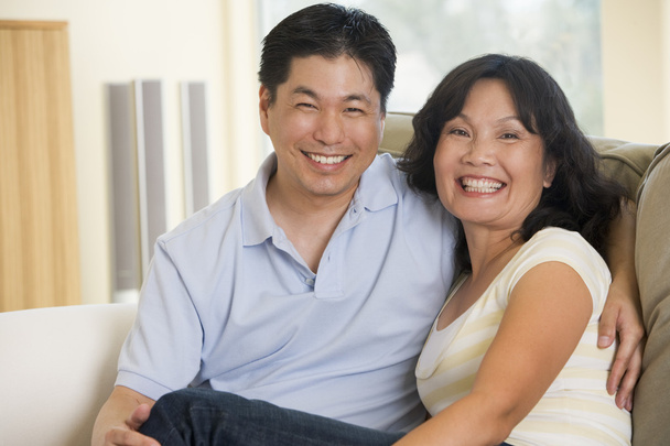 Couple relaxing in living room and smiling - Photo, Image