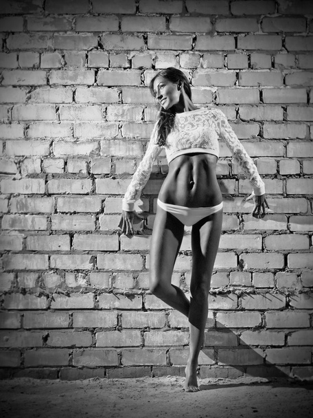 Young woman on brick wall (monochrome version) - Photo, image