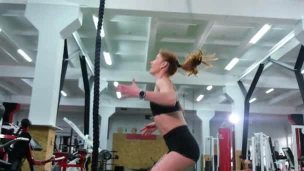 Femme s'entraîne sur une corde dans la salle de gym - Séquence, vidéo