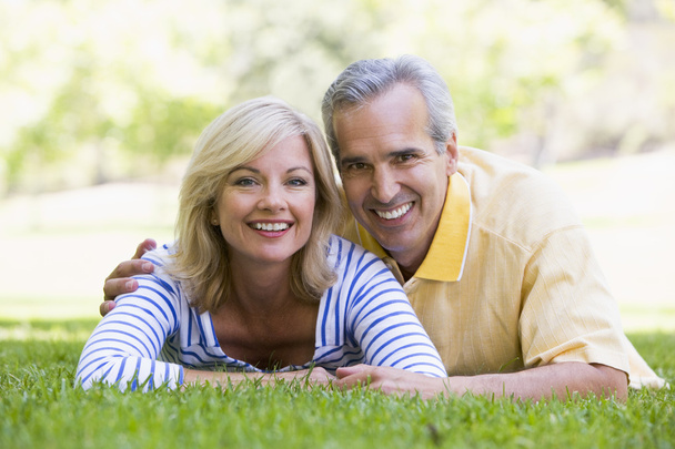 Couple relaxing outdoors in park smiling - Photo, Image
