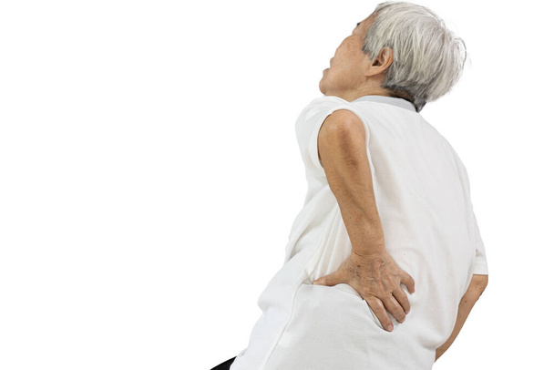 Літня жінка азіатського походження торкається стегна рукою, болить талія і болить лумбаго, проблеми з хребтом, літні люди страждають від болю у спині, масажують болючі або міцні м'язи спини, концепцію охорони здоров'я - Фото, зображення