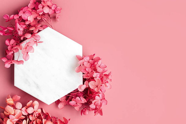Marble  hexagon on pink background with flowers. Stylish background for presentation. - Photo, Image