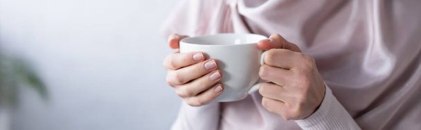 partial view of muslim woman holding cup of tea, banner - Fotó, kép