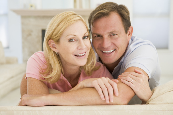 Couple relaxing in living room and smiling - Photo, image