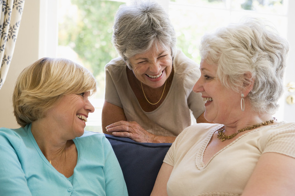 Three women in living room talking and smiling - Photo, Image