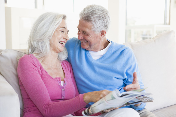 Couple with a magazine smiling - Foto, imagen