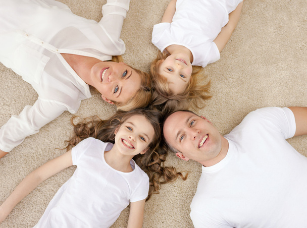 parents and two girls lying on floor at home - Valokuva, kuva
