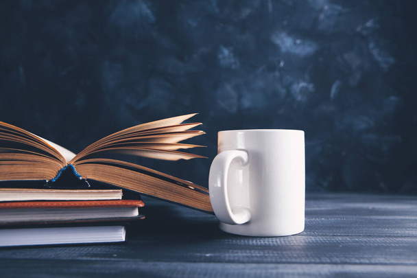 an open book and a cup on the table - Fotoğraf, Görsel