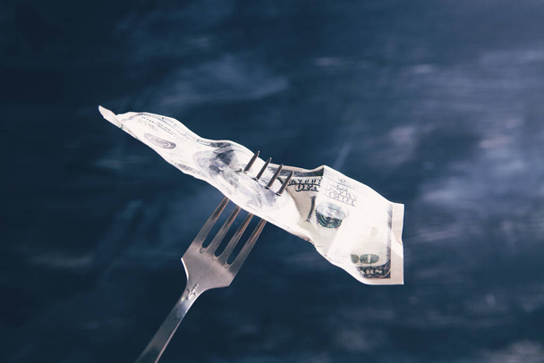 dollar on a fork on a black background - Foto, Imagen