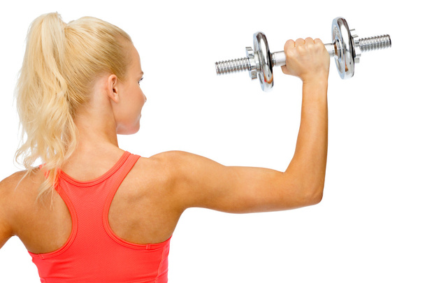 sporty woman with heavy steel dumbbell from back - Fotó, kép