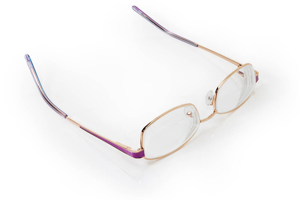 Современные классические очки для женщин в металлических желтых ободках с фиолетовыми элементами и храмами открытых очков на белом фоне - Фото, изображение