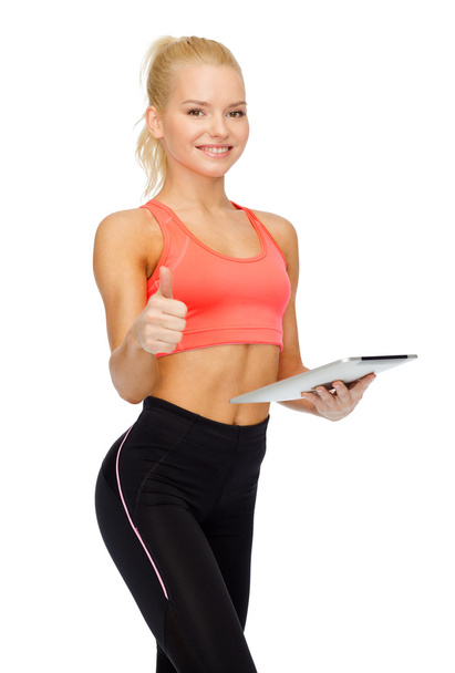 smiling sporty woman with tablet pc computer - Fotó, kép
