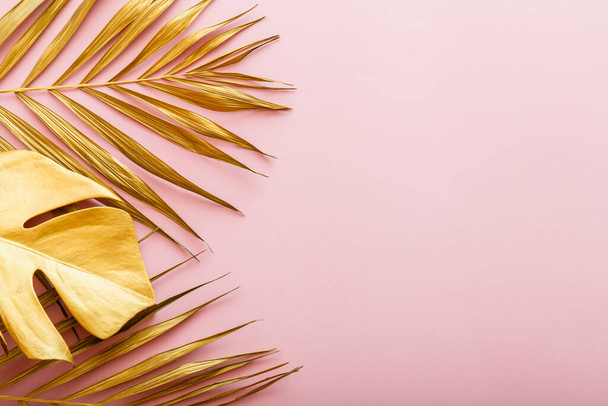 Golden palm leaf, tropical leave frame on pink background with copyspace. Summer backgroun gold floral frame. Flat lay - Fotoğraf, Görsel