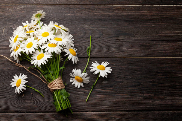 Garden camomile flowers bouquet on wooden table. Top view flat lay with copy space - Photo, Image